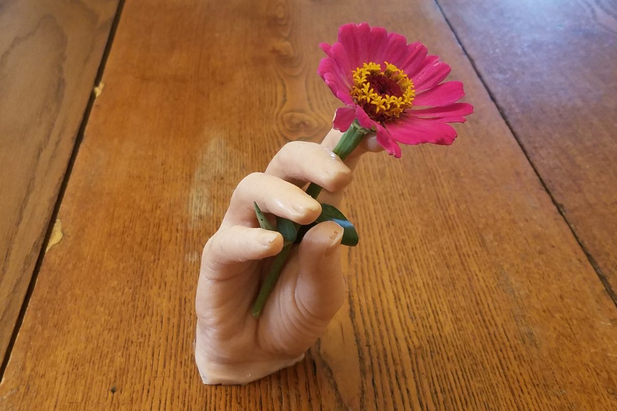 false hand with flower